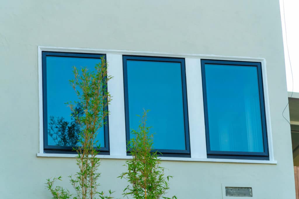 Row of low-e glass windows on white house.